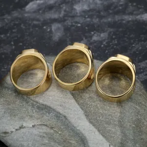 Close-up of golden titanium steel rings featuring intricate dragon pattern engraving