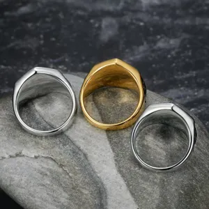 Detailansicht goldener und silberner Punk-Biker-Ringe aus Edelstahl auf einem Naturstein