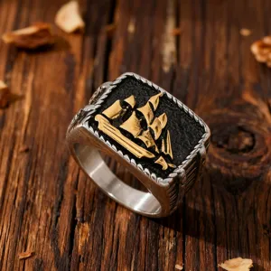 Vintage stainless steel men's ring featuring a golden sailing ship on black background