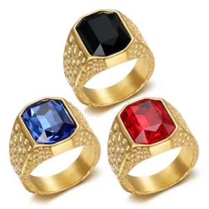 Macro detail of men's gold stainless steel rings with black blue and red gemstones