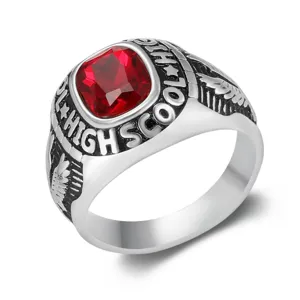 Macro view of a vintage stainless steel eagle school ring with a square red gemstone