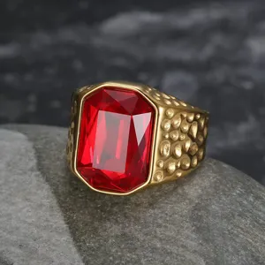 Close-up detail of a men's gold ring featuring a large red emerald-cut zircon stone.
