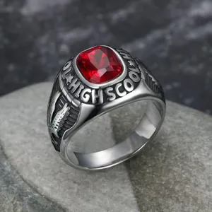 Macro detail of vintage eagle ring featuring a red gemstone and High School engraving.