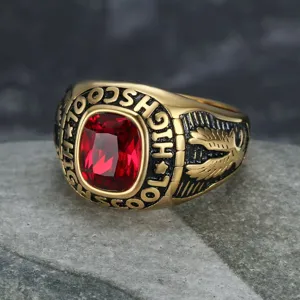 Detailed macro view of the faceted red gemstone and eagle relief on the gold-toned ring.