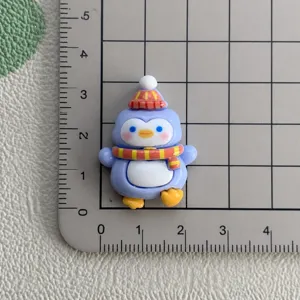 Cute penguin resin cabochon detail view showing size measurement on grid mat for DIY crafts.