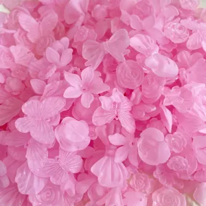 Dettaglio ciondoli fai da te in acrilico rosa satinato, simpatiche farfalle fiocchi e rose.