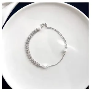 Detalle de tobillera de plata S925 con hojas de trigo y perlas, joyería para pies.