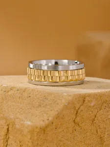 Detailed view of a men's stainless steel spinning ring with gold watch link design
