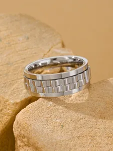 Close-up detail of men's stainless steel spinner ring with watch band texture