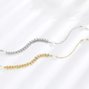 Detalle cercano de hojas de trigo y perlas de la elegante joya de tobillo de plata.