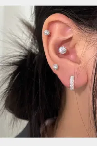 Vista detallada de elegantes pendientes de botón y aros en plata S999 con pavé brillante.