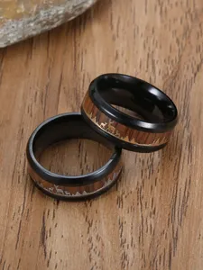 Macro view of black stainless steel ring with wood inlay and reindeer mountain engraving