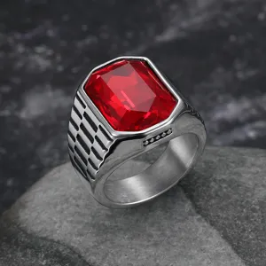 Macro detail of men's stainless steel ring with bold rectangular red gemstone.
