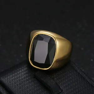 Macro view of men's gold stainless steel ring with a large black faceted zircon