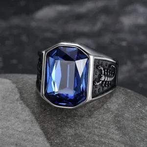 Primo piano dettagliato di un anello in titanio con gemma blu e design a scorpione