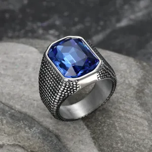 Close-up of retro stainless steel men's ring with large blue zircon and textured band