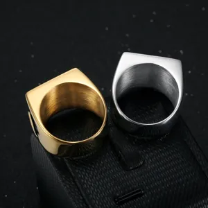 Close-up of gold and silver square signet rings with playing card spade engraving