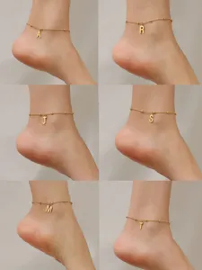 Detail view of 18K gold plated initial anklets with minimalist beaded chain design.