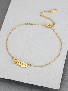 Close-up detail of a gold titanium steel anklet featuring the word Virgo in Old English font