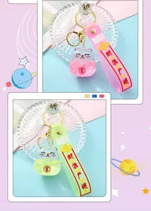Close-up details of the liquid quicksand lucky cat keychain with pink and green straps.