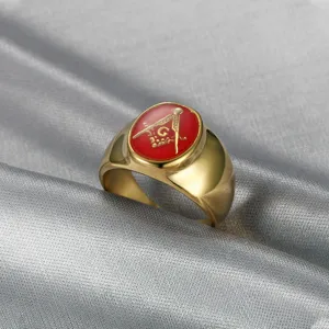 Macro view of gold Freemasonry ring with red enamel and square and compasses symbol