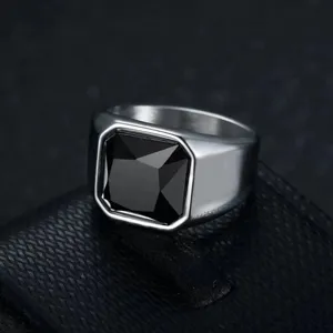 Macro view of a men's stainless steel ring featuring a square-cut black gemstone inlay.