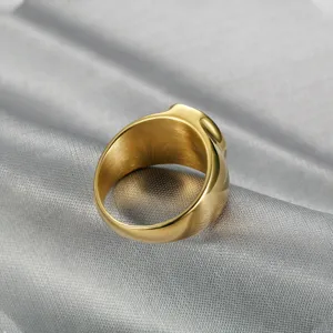 Detailed view of a polished gold men's chunky signet ring band on silver silk background