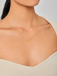 Gedetailleerd overzicht van minimalistische vergulde titanium stalen ketting op het sleutelbeen.