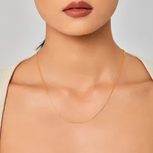 Close-up van een delicate vergulde titaniumstalen ketting om de nek van een model