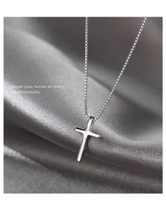 Detail van zilveren kruis hanger ketting met gepolijste metaaltextuur en fijne ketting.