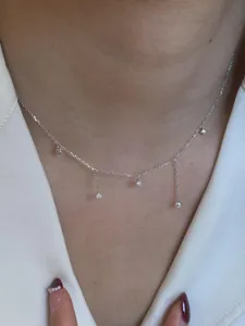 Delicate silver tassel necklace detail view, featuring sparkling zircon pendants.