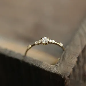 Primer plano de un delicado anillo de plata esterlina 925 con siete pequeñas piedras brillantes.