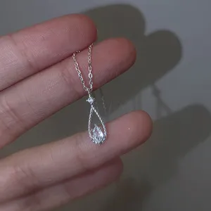 Primer plano de un collar con colgante de gota en plata sterling, piedra brillante.