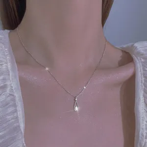 Vista detallada de un collar de clavícula de diamante con gota de plata esterlina, muy brillante.