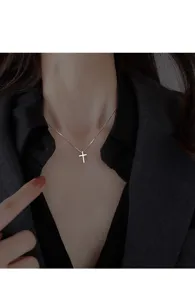 Mooie detail opname van de zilveren kruis ketting hanger in elegante minimalistische stijl.