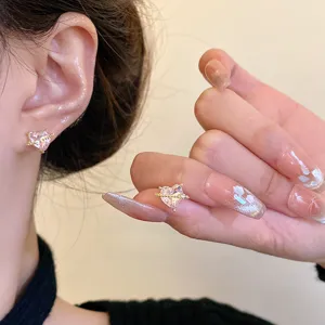 Delicados pendientes de botón con corazón de circonita rosa y elegante diseño de planeta.