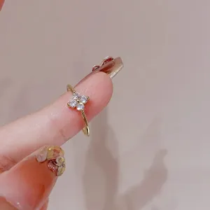 Close-up detail shot of a dainty gold clover ring with sparkling clear cubic zirconia.