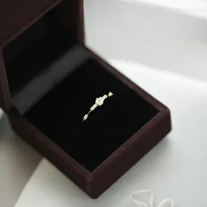 Primer plano detallado de un anillo de plata 925 delicado con pequeñas circonitas brillantes.