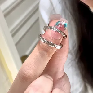 Vista detallada de anillos de pareja de plata con bandas retorcidas y con diamantes.