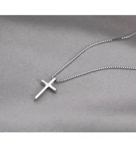 Delicate zilveren kruis hanger ketting detail opname, minimalistische sieraden stijl.