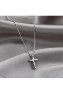 Detailopname van glad zilveren kruis hangketting op een achtergrond van zijde.