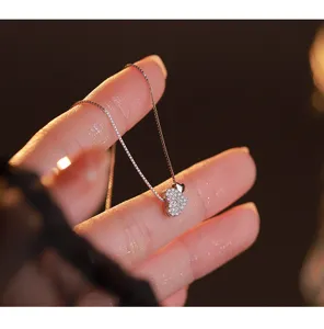 Primer plano de un delicado collar con colgante de doble corazon y piedras brillantes.