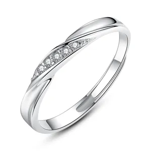Detalle en primer plano de anillo de pareja de plata con diseño retorcido y piedras brillantes.