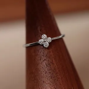 Sterling silver four leaf clover ring, delicate thin band, elegant minimalist design detail view.