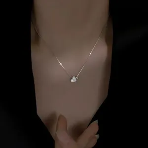 Primer plano detallado del collar con colgante de doble corazon en plata brillante.