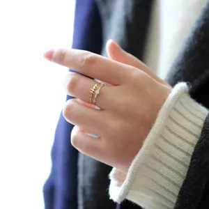 Detalle de anillo fino de plata S925, con pequeñas circonitas y un diseño de texto elegante.