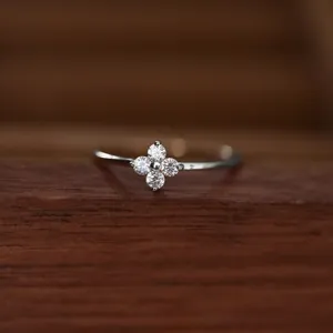 Detailed shot of a delicate S925 silver four leaf clover ring, minimalist everyday jewelry.