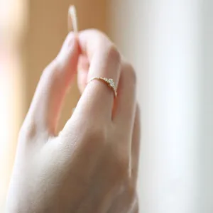 Primer plano detallado de un anillo fino minimalista de plata con piedras brillantes.