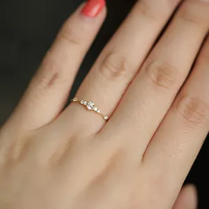 Delicado anillo de plata 925 con pequeñas piedras brillantes, elegante detalle de mano.