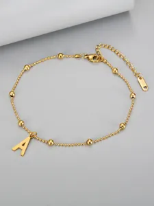 Detailed macro view of an 18K gold plated stainless steel beaded anklet with letter A